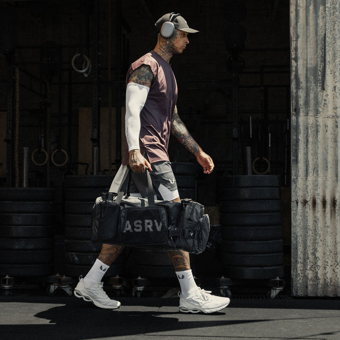Waterproof 2-in-1 Travel Duffle in black, carried by model in athletic wear