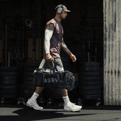 Waterproof 2-in-1 Travel Duffle in black, carried by model in athletic wear