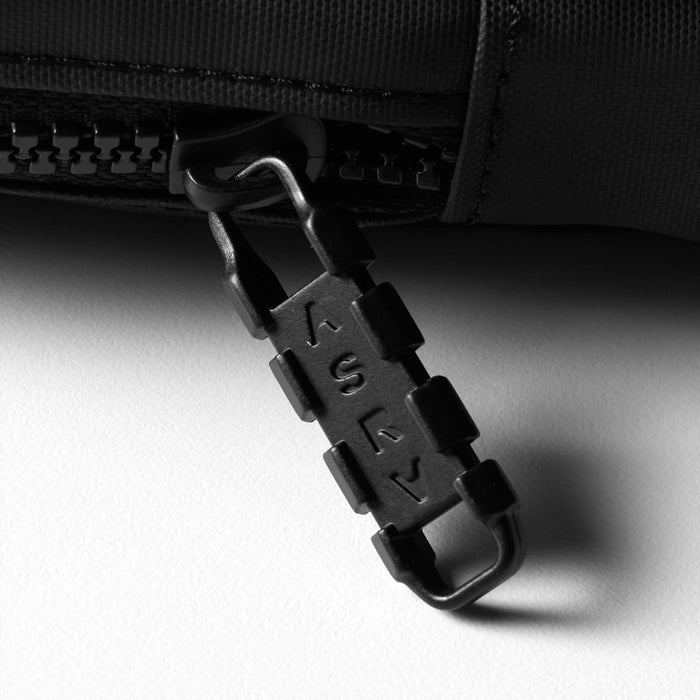flatlay of black waterproof phone holster bag with carabiner attachment, angled view