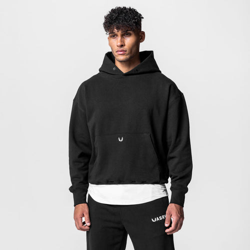 Black Tech-Terry hoodie worn by model with white undershirt, front view