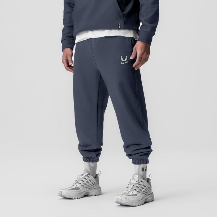 Tech-Terry Oversized Sweats in navy with emblem logo, worn by model with white sneakers