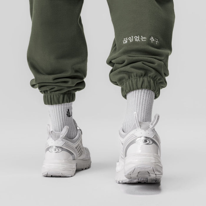 Tech-Terry Oversized Sweats in olive worn with white socks and sneakers, back view
