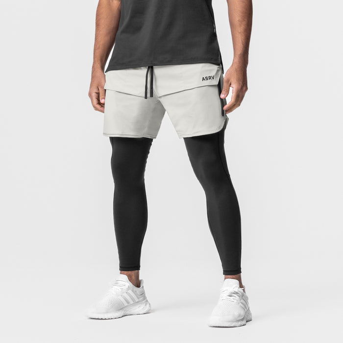 Tetra-Lite 7" Tech Short in stone worn with black leggings and white sneakers, front view
