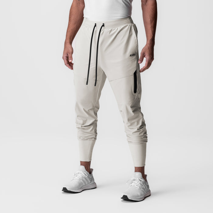 Tetra-Lite Tech High Rib Jogger in stone, worn by model standing against white background