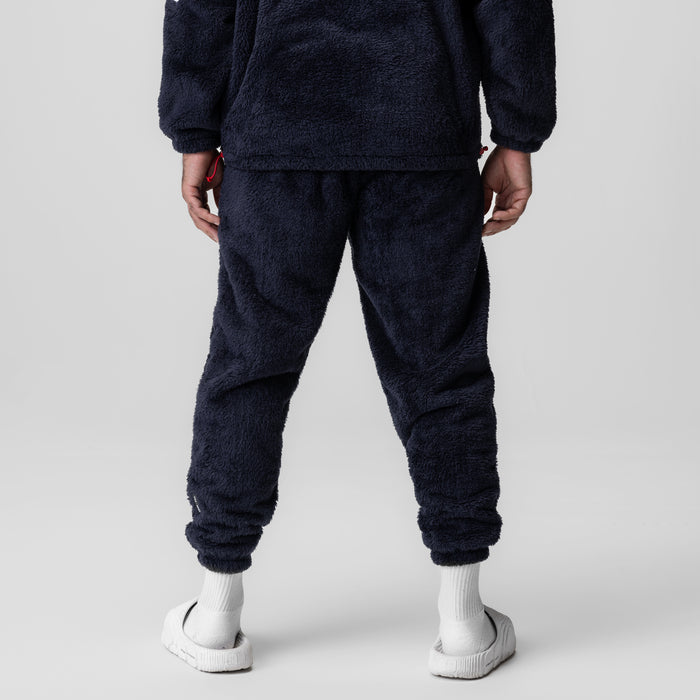 Sherpa Recovery Sweats in navy worn by model, back view with white socks