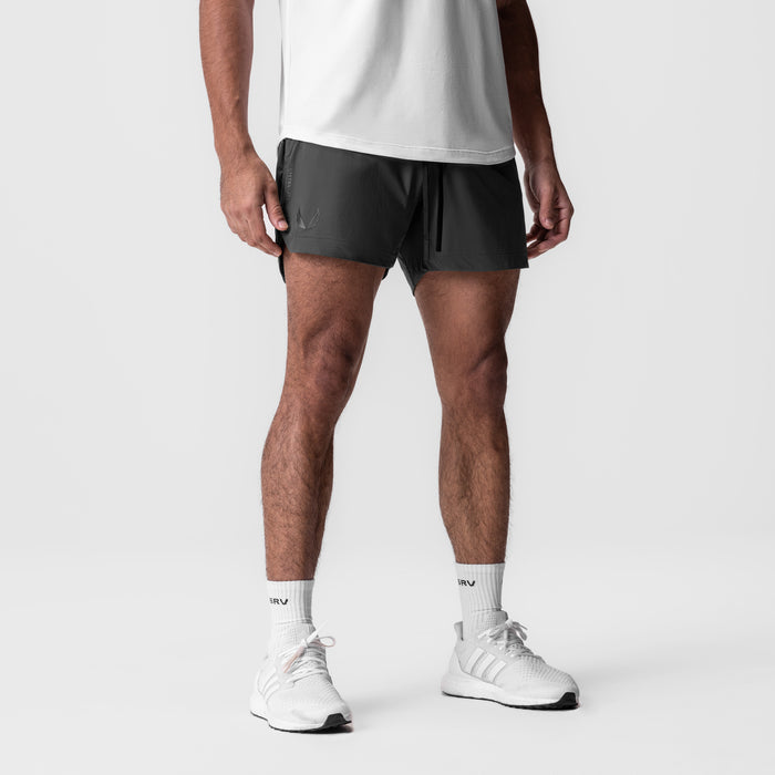 Tetra-Lite 5" Linerless Short in black, modeled on male figure with white socks and sneakers