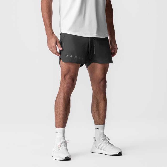 Tetra-Lite 5" Linerless Short in space grey, worn by male model with white sneakers and socks, front view