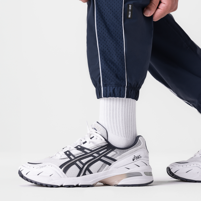 Navy ripstop oversized track pant worn with white socks and sneakers, side view