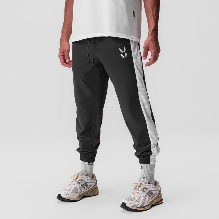 Ripstop Oversized Track Pant in black with grey side stripe, worn with white socks and sneakers