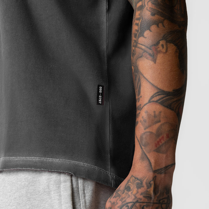 Tech Essential Relaxed Tee in faded grey worn by model with visible tattoos on arm