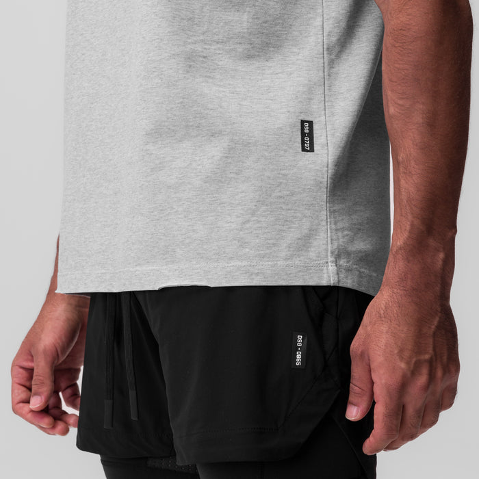 Tech Essential Relaxed Tee in heather grey worn by model, side view showing fit and length