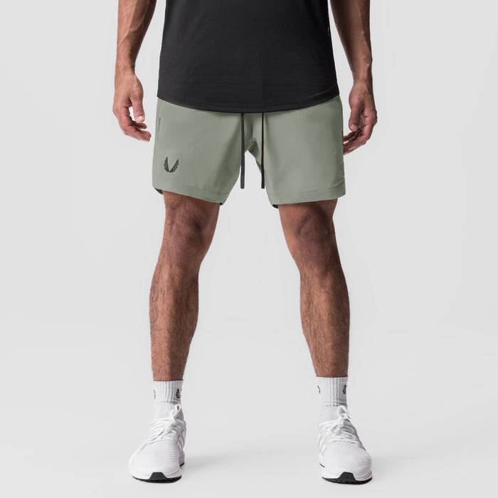 Tetra-Lite 7" Linerless Short in sage, modeled from front with white sneakers