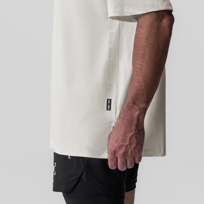 Ivory cream oversized tee worn by model with black shorts, side view