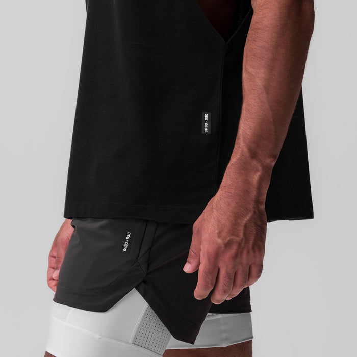Tech Essential Rocker Cutoff shorts in black, worn by model showing side view