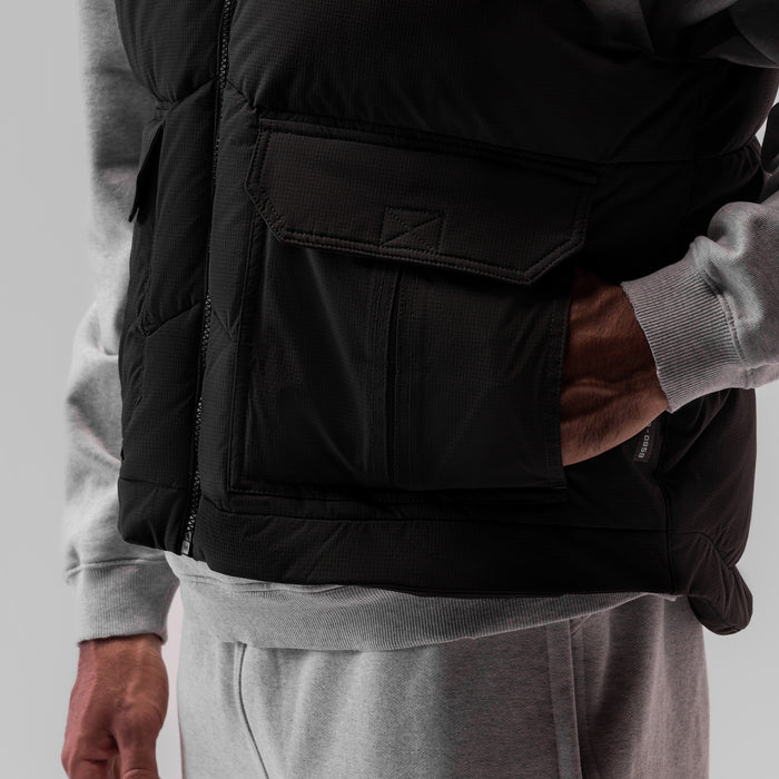 Black ripstop insulated puffer gilet worn over grey hoodie, side detail view