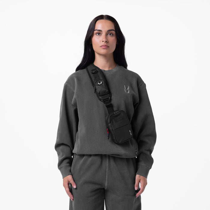Tech Essential Distressed Crewneck in Faded Grey worn with black sling bag, front view
