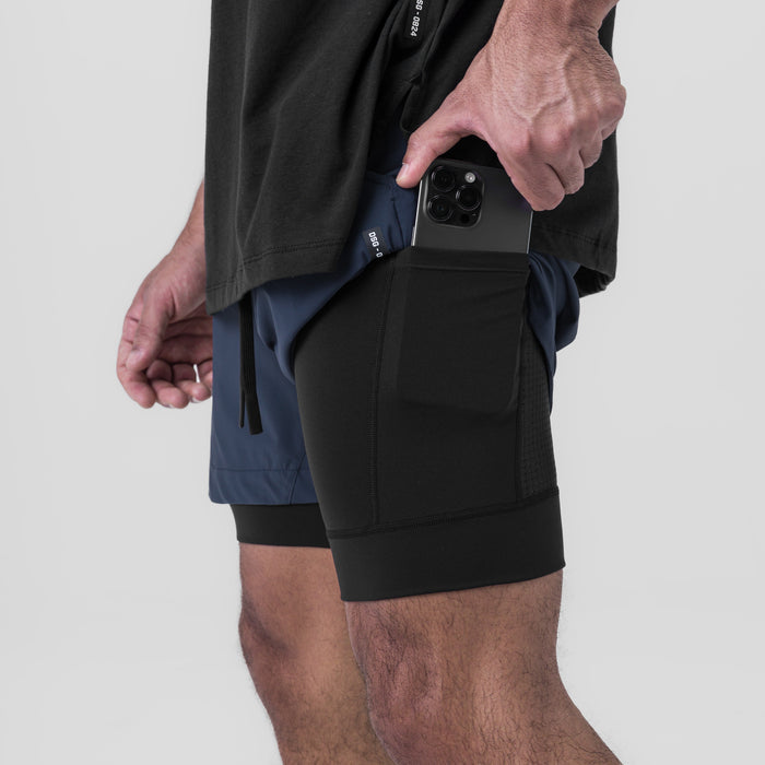 Tetra-Lite 5" Liner Short in Navy and Black, worn by model holding phone in pocket