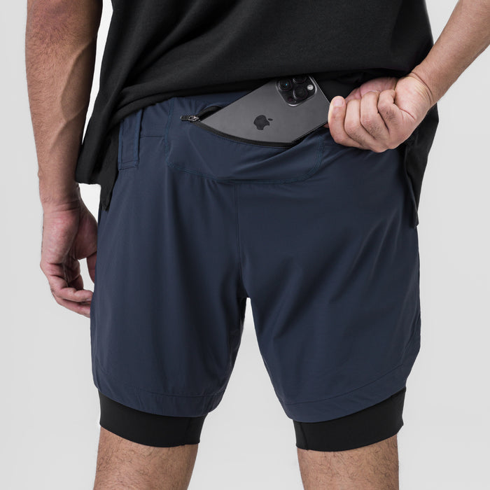 Tetra-Lite 7" Liner Short in navy and black, worn by model holding phone in front pocket
