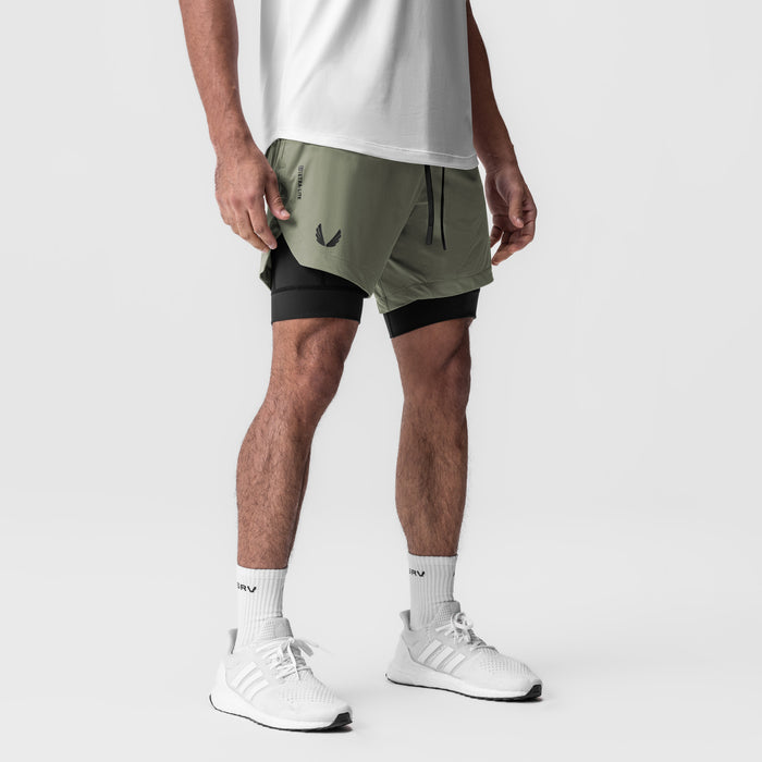 Tetra-Lite 7" Liner Short in sage and black, worn with white sneakers and socks