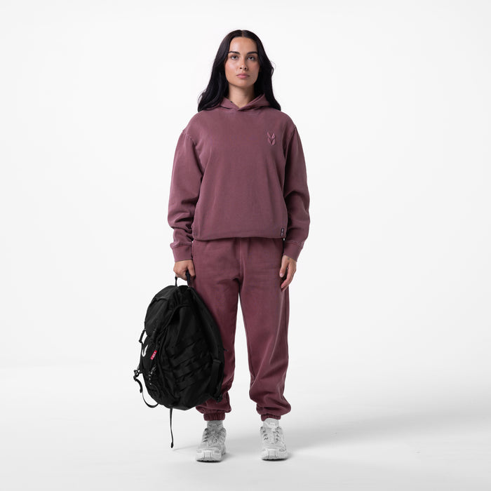 Tech Essential Distressed Hoodie in faded crimson worn with matching joggers, model holding black backpack