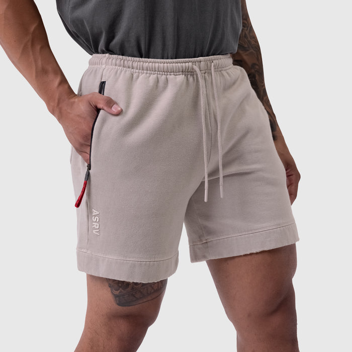 Tech Essential Sweat Short in faded chai worn by model, front view with hand in pocket