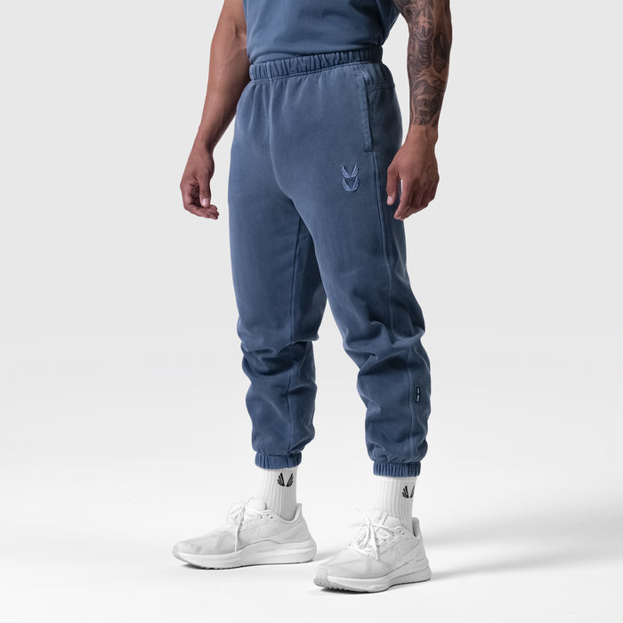 Tech Essential Sweats in faded navy joggers, worn by model with white sneakers, side view