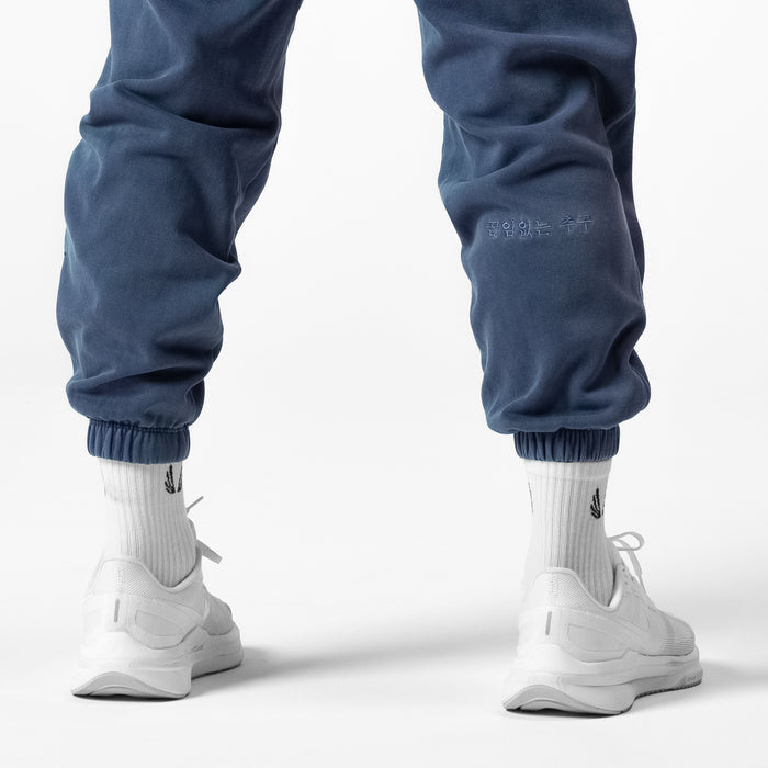 Tech Essential™ Sweats in faded navy worn with white socks and sneakers, back view