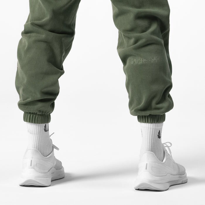 Tech Essential™ Sweats in faded olive worn with white socks and sneakers, back view