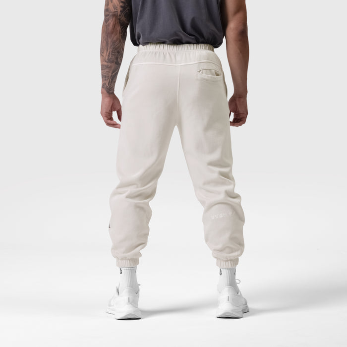 Tech Essential Sweats in faded stone, back view on model wearing black tank and white socks