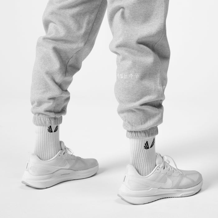 Tech Essential Sweats in heather grey, worn with white socks and sneakers, front view