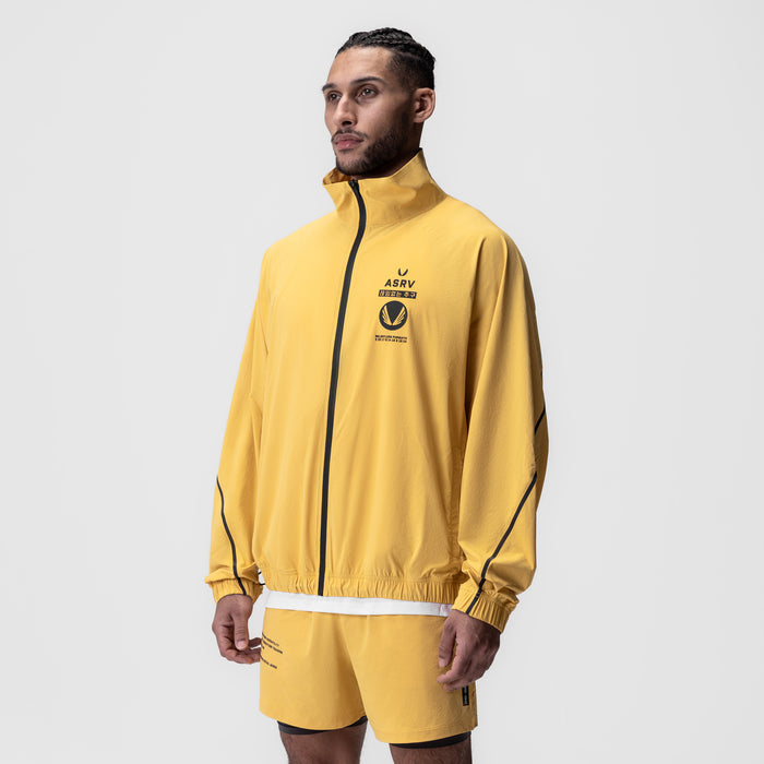 Aerotex Track Jacket in amber yellow with black trim, worn by model in three-quarter view