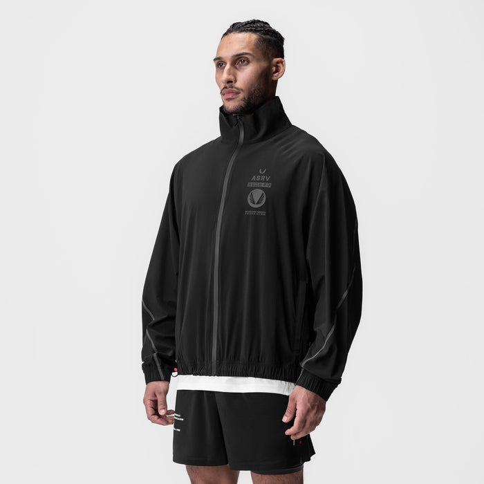 Aerotex Track Jacket in black with white stripe, worn by model in three-quarter view