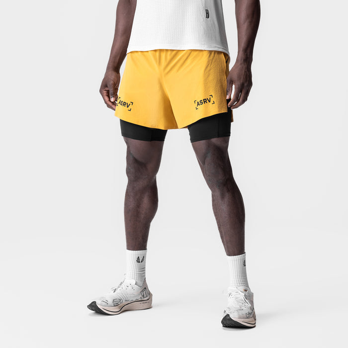 Aerotex 4" High Split Liner Short in amber yellow with black liner, modeled with white socks and sneakers