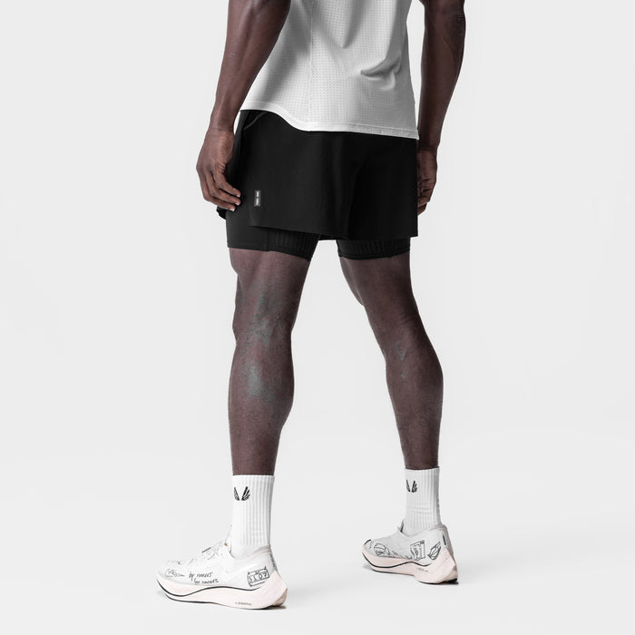 Aerotex 4" High Split Liner Short in black, worn by model from behind, paired with white socks and sneakers