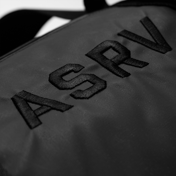 Flatlay of 0964 Barrel Gym Duffle Bag 30L in black, close-up detail of embroidered logo