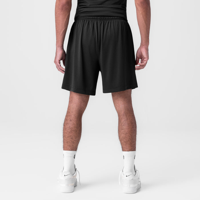 Black reversible 2-in-1 shorts on model, back view, worn with white socks and sneakers