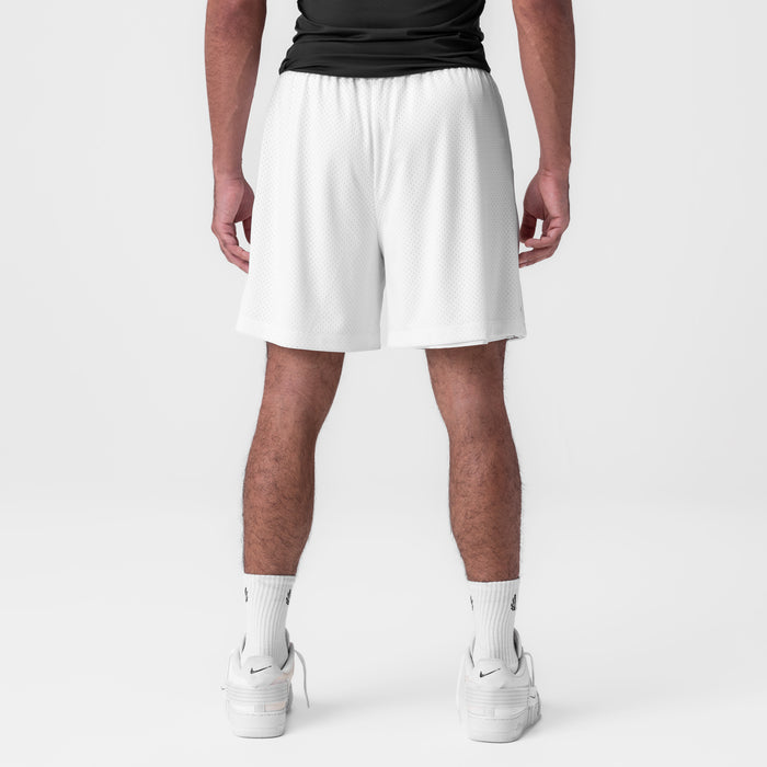 Reversible 2-in-1 shorts in white, back view on model wearing black top and white socks
