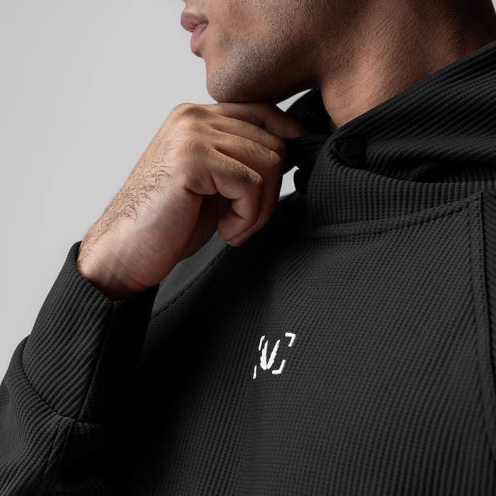 Deltapeak® Oversized Hoodie in black, worn by model adjusting hood