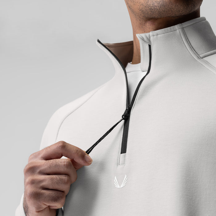 Dri-Core Quarter Zip in light grey, worn by model holding zipper detail