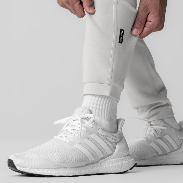 Dri-Core Training Jogger in light grey worn with white sneakers and white socks, side detail view
