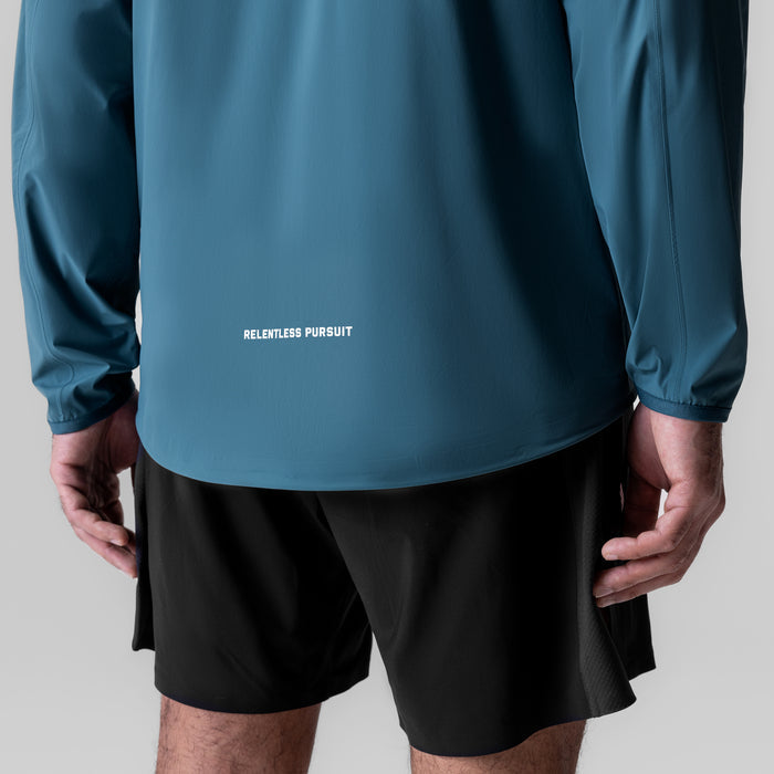Aerotex Lightweight Windbreaker in storm blue worn with black shorts, back view