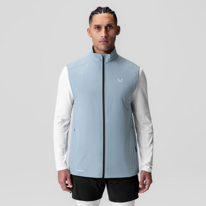 Aerotex PrimaLoft Run Vest in light sky, worn by model with white long-sleeve shirt and black shorts