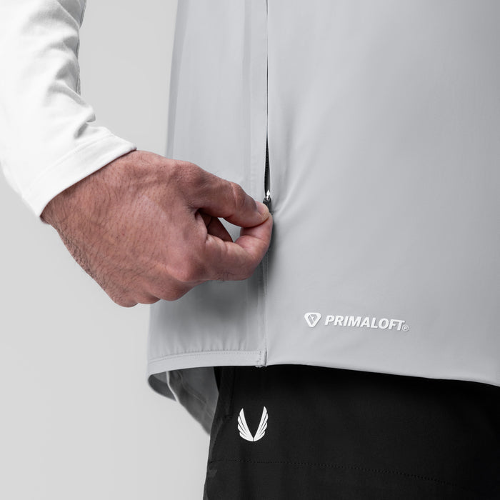 Aerotex™ PrimaLoft® Run Vest in slate grey, being held by model wearing white long-sleeve shirt