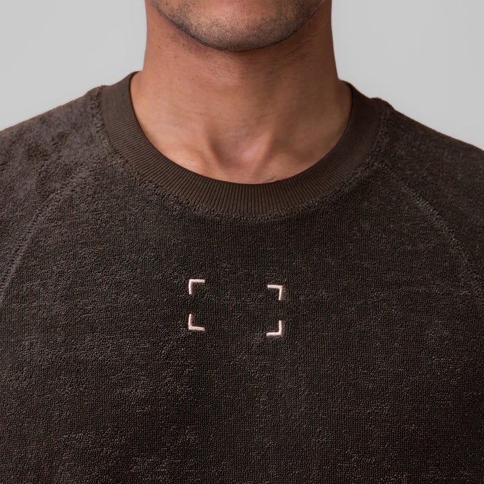 Towel Terry Cutoff in Dark Earth worn by model, front view showing embroidered logo detail