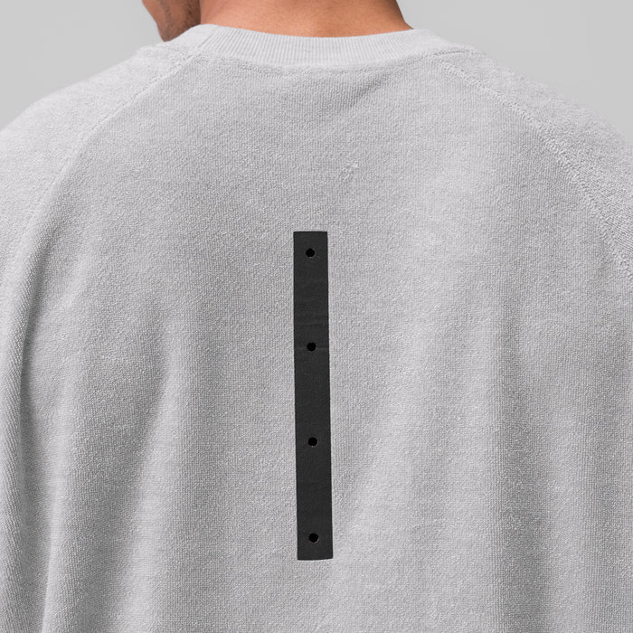 Towel Terry Cutoff in heather grey worn by model, back view showing black button detail