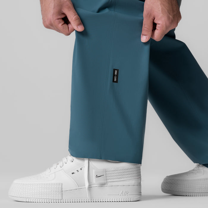 Tetra-Lite Field Pant in storm blue worn with white sneakers, front view
