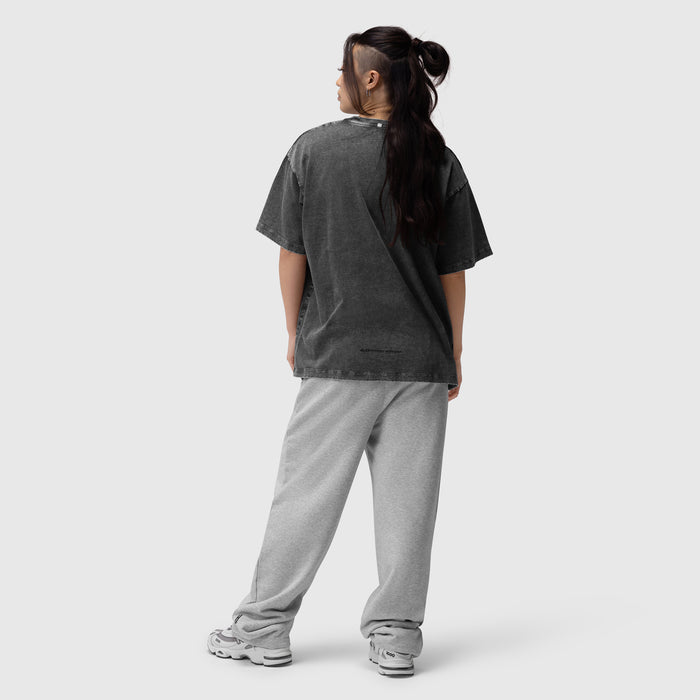 Distressed relaxed tee in black worn with grey joggers, back view
