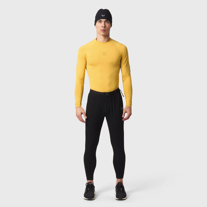LYCRA® ADAPTIV Baselayer Longsleeve in amber yellow worn with black leggings, front view