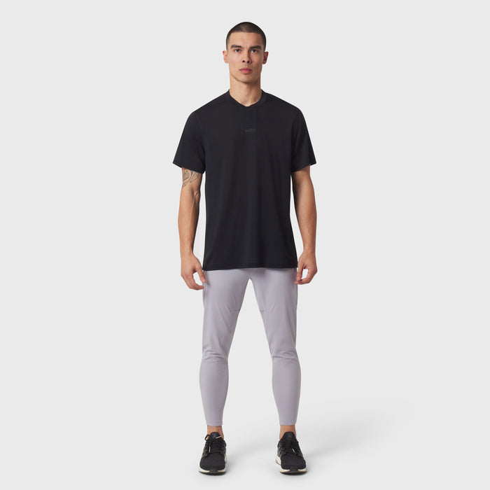 Black v-neck t-shirt with grey leggings and black sneakers, front view on model