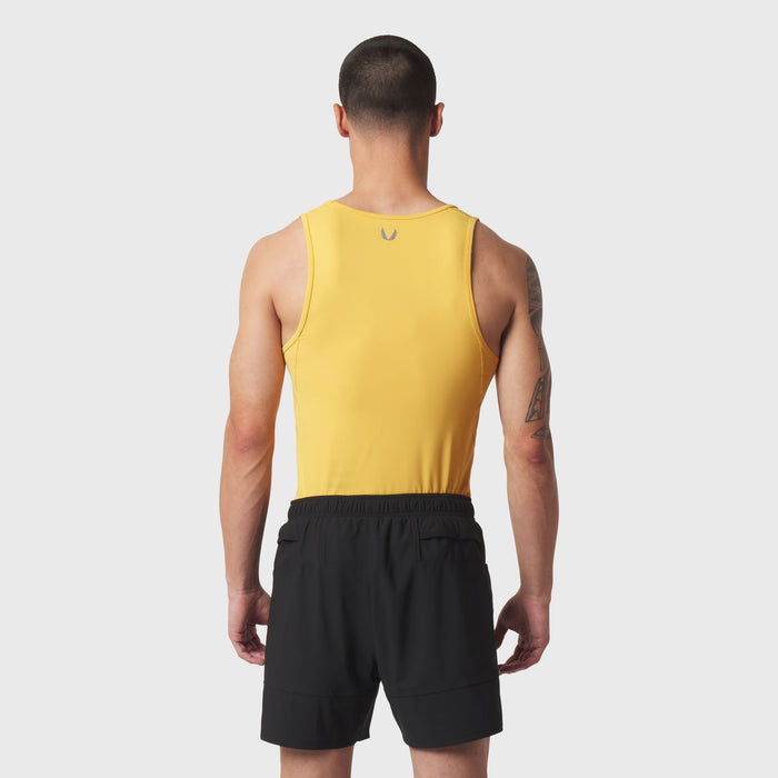Amber LYCRA® ADAPTIV baselayer tank on model, back view, paired with black shorts